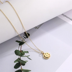 Dettaglio collana LOVE dorata con ciondolo a sorriso in zircone e pietre colorate