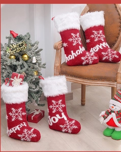 Detail view of 4 knit Christmas stockings with white faux fur trim and snowflake patterns