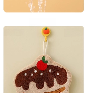 Detail of a chocolate cake style coral fleece hand towel with a strawberry embroidery