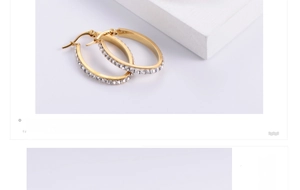 Macro detail of gold-plated oval earrings featuring micro-pave cubic zirconia inlay
