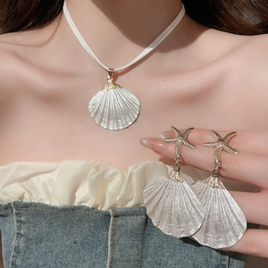 Detail showing shell necklace and starfish earrings on model for beach vacation style