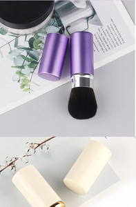 Macro detail of retractable makeup brushes in purple and beige with soft brown fiber bristles