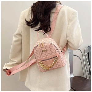 Detail of pink mini backpack with 'M' pattern and decorative gold chain on the back