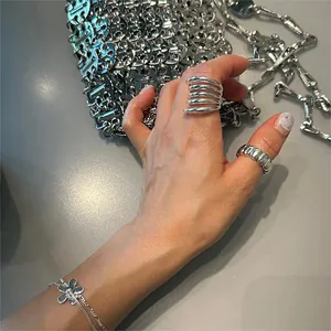 Close-up of minimalist S925 sterling silver layered rings and floral charm bracelet