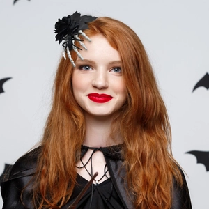 Halloween hair clip featuring a black rose and white skeleton hand on a female model
