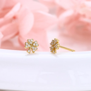 Macro shot of s925 silver four-leaf clover stud earrings with paved sparkling zircons