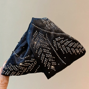 Detailed close-up of acrylic triangle hair claw with sparkling rhinestones and silk texture