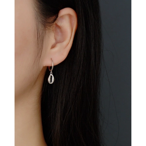 Close-up of S925 sterling silver shell earrings worn by a model against dark background