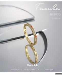 Detail of gold-plated ring with white zircon pave setting and red heart epoxy charms
