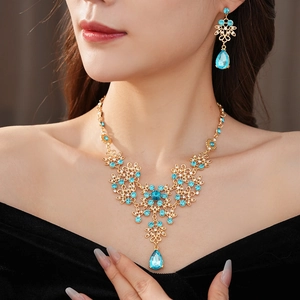 Detail of vintage gold necklace and earrings with sky blue crystal flower pendants