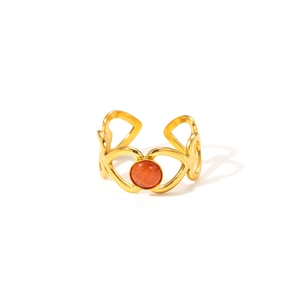 Détail d'une bague cœur ajourée plaquée or 18k avec incrustation d'œil de chat orange