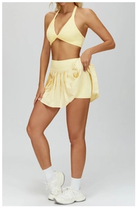 Detail of pale yellow tennis skirt with built-in safety shorts and pleated design