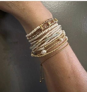 Detail of layered stainless steel bead and pearl bracelets on wrist with adjustable clasp