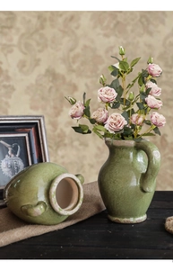 Detail van groene keramische vaas met craquelé glazuur, handvat en vintage landelijke stijl