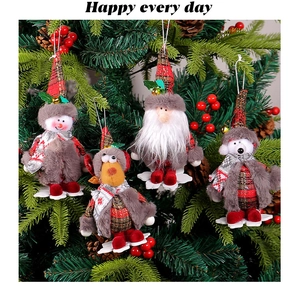 Close-up of plush reindeer and snowman ornaments hanging on a festive Christmas tree branch