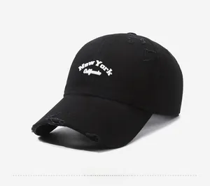 Close-up of distressed black baseball cap with white New York California embroidery