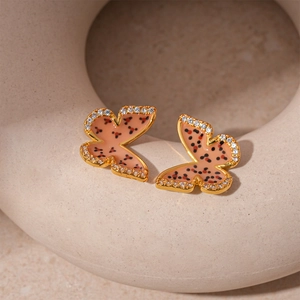 Detail of gold-plated butterfly earrings with pink enamel, polka dots and pavé zircons