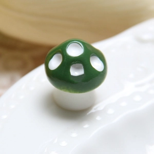 Macro shot of a small green resin mushroom with white spots for DIY micro landscapes