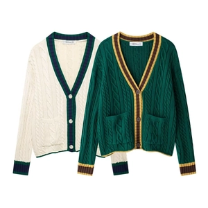 Detail of V-neck cable knit cardigans with contrast stripes and textured knit fabric