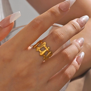 Irregular lava texture 18K gold plated stainless steel ring shown on model's finger