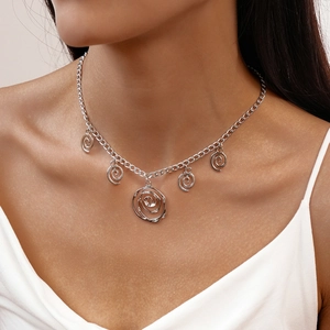 Detail view of a silver minimalist necklace with five spiral circular pendants on a model