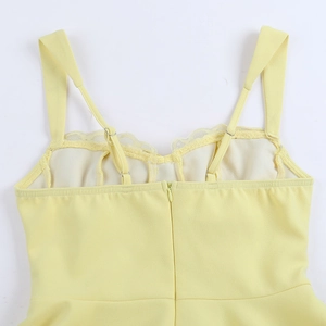 Détail de la robe jaune à bretelles avec fermeture éclair invisible et bretelles avec dentelle
