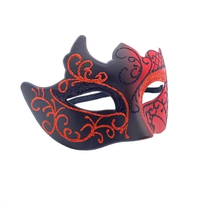 Detail view of Venetian masquerade mask with red and black gradient and glitter scrolls