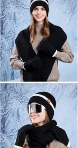 Close-up of winter knitted set with beanie, scarf and gloves featuring white stripes