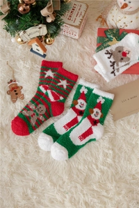 Détail de chaussettes de Noël chaudes en velours corail avec motifs festifs d'élans et bonshommes