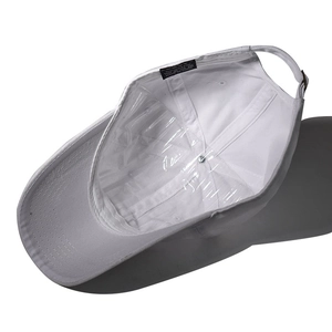 Detail view of cotton baseball cap interior showing white fabric and metal adjustment buckle