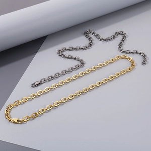 Detail of 7mm stainless steel link chains in gold and dark grey with lobster clasps