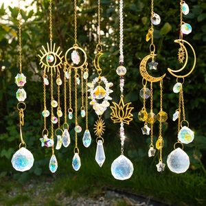 Detail of K9 crystal suncatchers with gold moon and lotus hanging in a garden