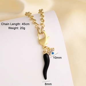 Macro detail of 18k gold plated necklace with evil eye and black chili horn charms