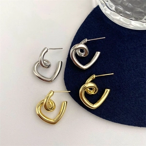Unique heart-shaped twist stud earrings in gold and silver finish with a modern minimalist design
