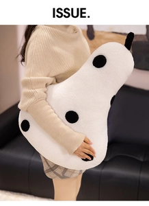 Close-up of oversized pear shaped plush pillow with black polka dots on teddy fleece fabric