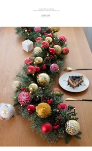 Detail of 135cm Christmas garland with LED lights, red and gold balls on wooden table