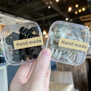 Primer plano de mini pinzas para el cabello mate en cajas con etiquetas hechas a mano
