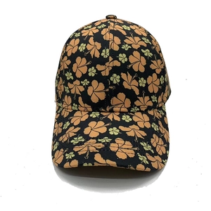 Détail d'une casquette noire avec des motifs de fleurs d'hibiscus orange et vert vif