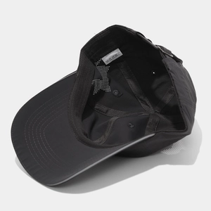 Detail of black quick-dry nylon cap showing internal sweatband and breathable laser-cut holes