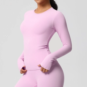 Détail d'un haut de yoga rose à manches longues avec passe-pouces et haute élasticité