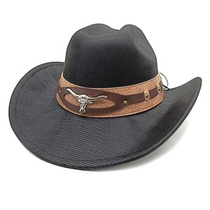 Detail of western cowboy hat featuring silver bull head emblem and studded leather band