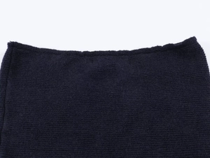 Detailed macro view of dark navy textured tweed knit fabric with frayed edge accents