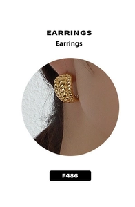Close-up of gold croissant twist hoop earrings worn by a model for a modern fashion look