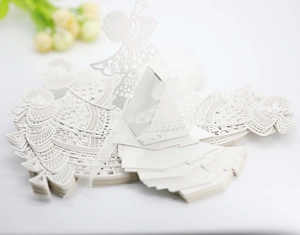Macro shot of white laser-cut angel favor box with intricate hollow patterns for weddings
