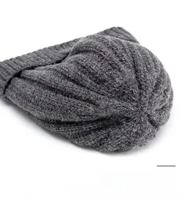 Macro detail of dark grey knitted beanie showing durable top seam and thick wool texture