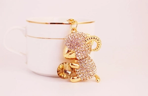 Close-up of golden sheep keychain with inlaid crystals and large amber gemstone