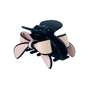 Detailed view of large black hair claw clip featuring elegant pink resin bow accents
