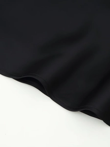Gros plan détaillé du tissu satiné noir lisse et des coutures de haute qualité sur le vêtement