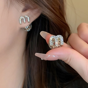 Boucles d'oreilles lettre M en zircon avec sphère creuse et détails géométriques