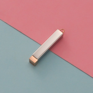 Close-up of a dual-tone cylindrical pendant in silver and rose gold finish